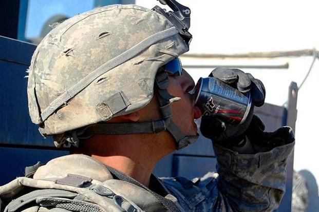 A soldier drinks an energy drink before his patrol in Iraq. (Photo: health.mil)