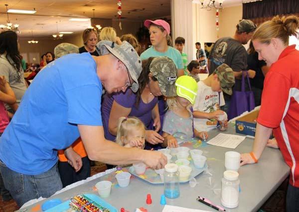 Family members visit the sand art table to make colorful creations during the Month of the Military Child event at Thunder Mountain Activity Centre, Fort Huachuca. (Photo Credit: Gabrielle Kuholski)