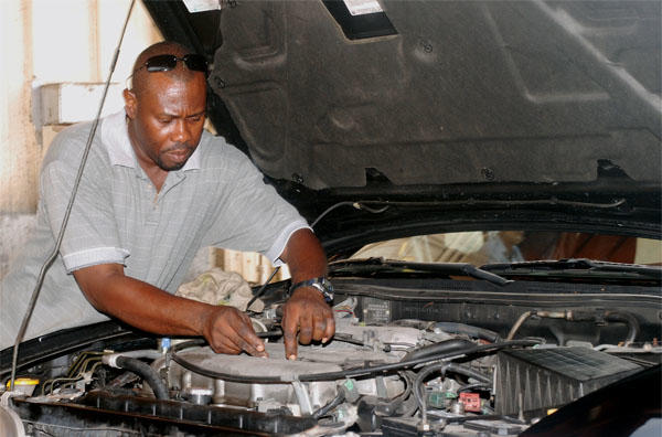 man looking under car hood