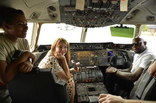 The Magnificent 7 director Antoine Fuqua (right) and movie actress Haley Bennett visit the cockpit of a USAF KC-10 tanker prior to a USO-sponsored film premiere at Joint Base McGuire-Dix-Lakehurst, New Jersey, September 18, 2016. The cast members and director toured the flightline, greeted service members and met with military families to extend their appreciation for their service. USO Photo by Mike Theiler