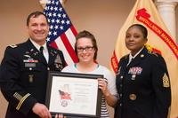 Joint Base Myer-Henderson Hall Commander Patrick M. Duggan and Command Sgt. Maj. Carolyn Y. Donaldson present military spouse Mrs. Lori Thompson with a Volunteer of the Year award. (U.S. Army/Daniel Yeadon)
