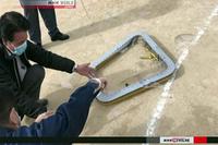 This image from an NHK broadcast shows a window from a CH-53E Super Stallion helicopter after it fell onto an elementary school sports field near Marine Corps Air Station Futenma, Okinawa, on Dec. 13, 2017. Screenshot from NHK