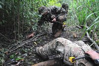 A student at the Jungle Operations Training Center in Oahu, Hawaii, trains on checking for IEDs as he works his way back to an injured soldier. (US Army photo/Jay Koester)