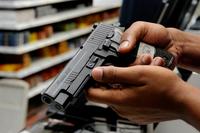 A patron at the Barksdale Base Exchange shops for a new pistol. The Gun Shop offers a wide variety of weapons including pistols, rifles, shotguns and pellet guns. (USAF photo by TSgt Laura K. Smith)