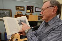 Johnie Webb, deputy of outreach and communications for the Defense POW/MIA Accounting Agency, points to a photo of him published in a book on U.S.-Vietnam diplomatic relations after the war inside his office at Joint Base Pearl Harbor-Hickam, Hawaii, March 13, 2018. Webb, a retired lieutenant colonel and Vietnam War veteran, was part of the first recovery team to enter Vietnam following the war in search of missing American service members. (U.S. Army photo/Sean Kimmons)