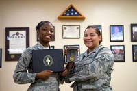 U.S. Air Force Senior Airman Ralecia Ogburn and Airman 1st Class Amari Alexander, 6th Medical Operations Squadron aerospace medical technicians display their Joint Service Commendation honors at MacDill Air Force Base, Fla., Dec. 20, 2018. Ogburn and Alexander distinguished themselves by providing urgent medical treatment and life-saving aid to a critically wounded civilian at a parachute airdrop zone. (U.S. Air Force photo/Caleb Nunez)