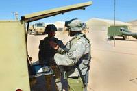 U.S. Army 1st Lt. Dat Dang and Sgt. Maurice Wendorf of the 98th Expeditionary Signal Battalion discuss the functions of a Supply Terminal Trailer at Fort Irwin, California, on May 10, 2016. The STT is a satellite that can provide online capabilities for frontline troops' computer systems anywhere in the world. (U.S. Army photo by Spc. Adam Parent)