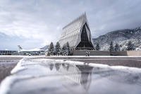 The Cadet Chapel and F-16 reflect on the tiles of The Terrazzo at the U.S. Air Force Academy on Oct. 31, 2018 after a few inches of snowfall blanketed the region overnight. (U.S. Air Force photo/Trevor Cokley)