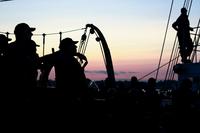 U.S. Coast Guard Academy Cadets stand helm watch as the Coast Guard Tall Ship Eagle.