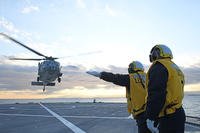 Sailors direct the launch of an MH-60S Sea Hawk helicopter from the USS Blue Ridge