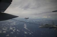 An F/A-18 Hornet flies behind a KC-130J Super Hercules.