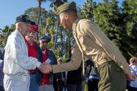 A Marine officer shakes hands with a veteran of the Battle of Iwo Jima.