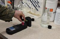 A water and fuels system maintenance technician uses an analyzer to test water samples at McConnell AFB.