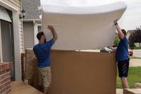 Movers pack a military members property into boxes and load it into crates to be transferred to a temporary storage facility in O'Fallon, Illinois, July 1, 2019.