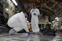 Dillan Cunningham and Jake Ferry collect surface samples during C-17 Globemaster III aircraft airflow testing.