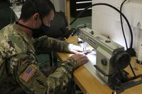 Army Staff Sgt. Johnny Kazmierczak sews a cloth face covering.