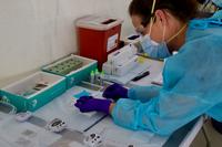 A nurse at the Miami Beach Convention Center Community Based Testing Site conducts a COVID-19 antibody test on May 22, 2020.