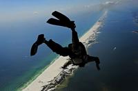 U.S. Air Force members from the 23rd Special Tactics Squadron jump out of the back of a C-130.