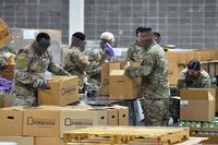 Louisiana National Guard soldiers prepare food boxes for distribution during the COVID-19 response