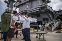 Sailors assigned to USS Theodore Roosevelt prepare to return following completion of their off-ship quarantine.