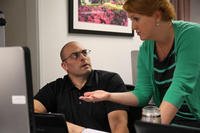 woman assisting man with computer