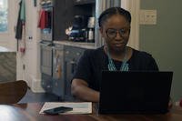 woman sitting at table on computer