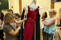 women looking through a rack of gowns