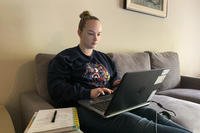 woman working on laptop while sitting on the couch