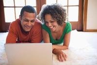 Happy couple looking at laptop together