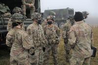 Soldiers talk among themselves during a mock indirect fire at Grafenwoehr Training Area.