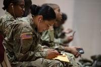 A trainee from Fort Jackson smiles as she speaks to loved ones over her cell phone. 