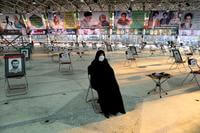 An Iranian woman wearing a mask attends a ceremony on the anniversary of death of Qasem Soleimani.