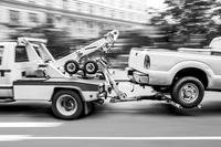 Pickup truck being towed by tow truck
