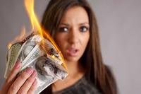 Woman holding a handful of burning cash