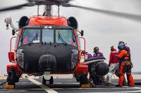 Coast Guard MH-60T helicopter lands on the deck of the San Antonio-class amphibious transport dock ship USS Arlington