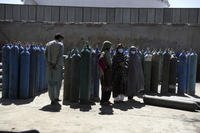Women wait inside a factory to get their oxygen cylinders refilled in Kabul, Afghanistan.