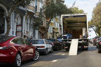 A moving truck sits on a city block.