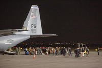 Families evacuated from Kabul, Afghanistan, walk past a U.S Air Force plane.