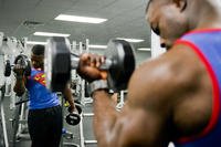 Senior airman uses dumbbells to perform biceps curls.