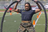Marine performs weighted jumping jacks with ropes.
