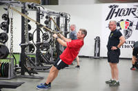 A command sergeant major performs a TRX row.