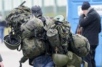 A man carries combat gear as he leaves Poland to fight in Ukraine.