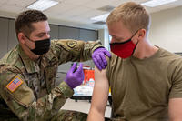 Army Spc. Tristan Spoerri, with the Utah National Guard Medical Detachment, administers the first dose of the COVID-19 vaccine to a soldier on Camp Williams, Utah.