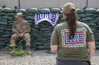 USO volunteer while time while soldiers conduct wall squats at Erbil Air Base.