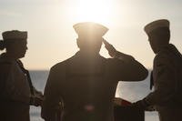 A sailor salutes during a burial at sea.