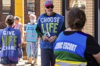 Anti-abortion protester attempts to talk to a clinic escort.