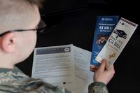 An airman reads pamphlets on the Montgomery GI Bill and the Post-9/11 GI Bill.