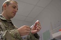 U.S. Air Force airman prepares a vaccine at Ramstein Air Base
