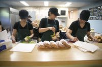 Volunteers at the USO on Camp Courtney in Okinawa, Japan, prepare lunch for the grand opening of a new location.