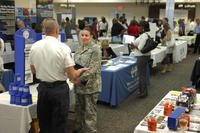 U.S. Army Staff Sgt. Dominique Lee, Third Army/AECENT communications technician, speaks with Dennis Dobbs, Department of Corrections lieutenant recruiter, about potential job opportunities during a job fair at Shaw Air Force Base, S.C.